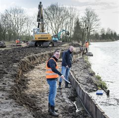 Twee mannen die damwanden hergebruiken bij het water.