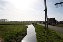 Impressiefoto ter hoogte van de molen in Bonrepas na het afronden van de werkzaamheden. Het binnentalud is breder geworden en de palen van het stabiliteitscherm zijn gelijk met het waterpeil