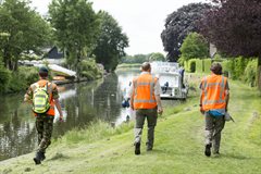 Waterschapsmedewerkers en militairen inspecteren de dijken