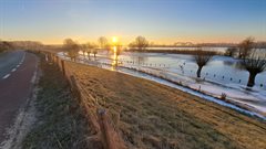 Lekdijk met ijs op het water