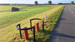 Peilbuizen die aan de binnenkant van de dijk staan