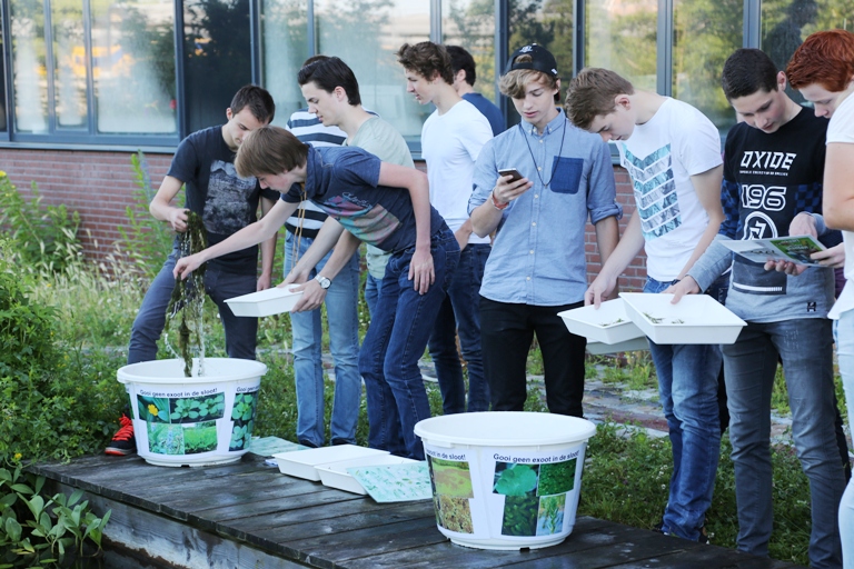 Leerlingen met emmers water